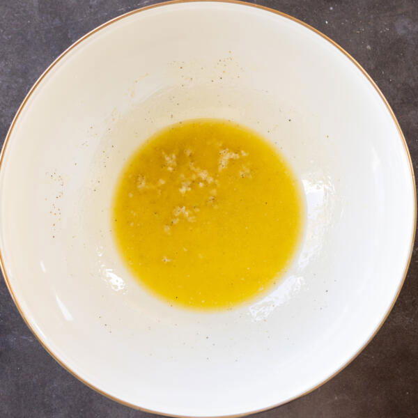Melted butter with garlic and seasoning in a bowl.