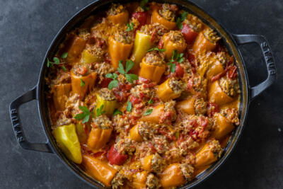 Stuffed Mini Peppers in a serving pan and herbs.