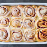 Cranberry Cinnamon Rolls with Orange Glaze baked in a pan.