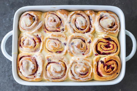 Cranberry Cinnamon Rolls with Orange Glaze baked in a pan.