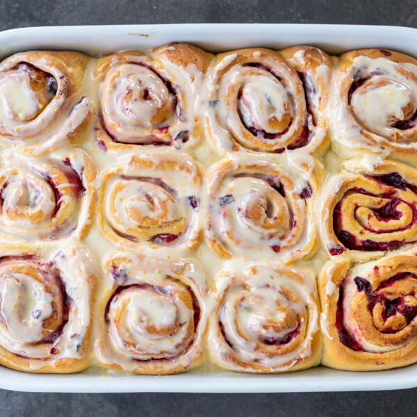 Cranberry Cinnamon Rolls with Orange Glaze baked in a pan.
