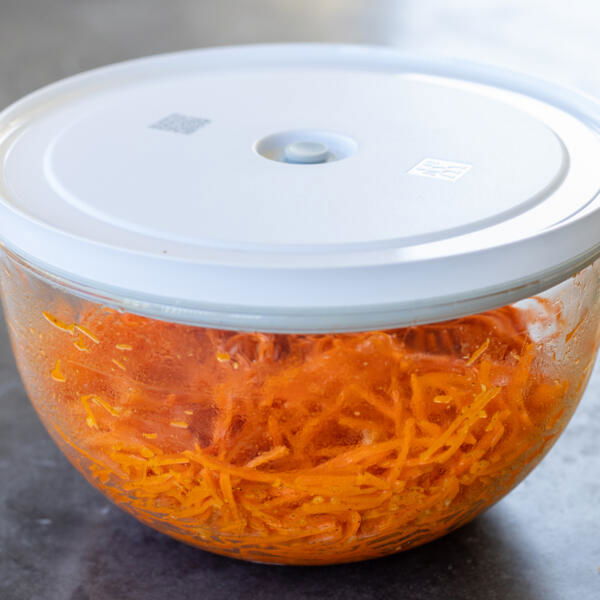 Korean Carrot Salad in a bowl with a cover.