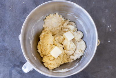 Dough combined in a bowl with butter.