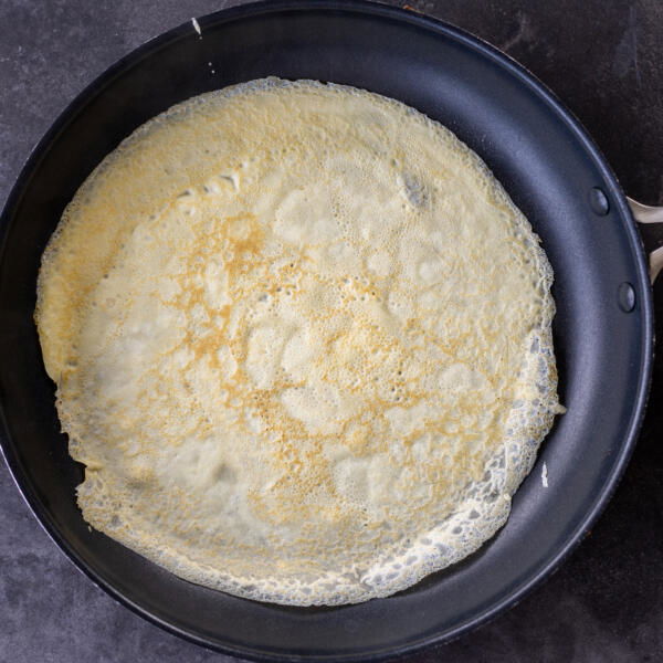 Crepe cooking in a pan.
