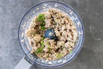 Blended meat with herbs in a food processor.