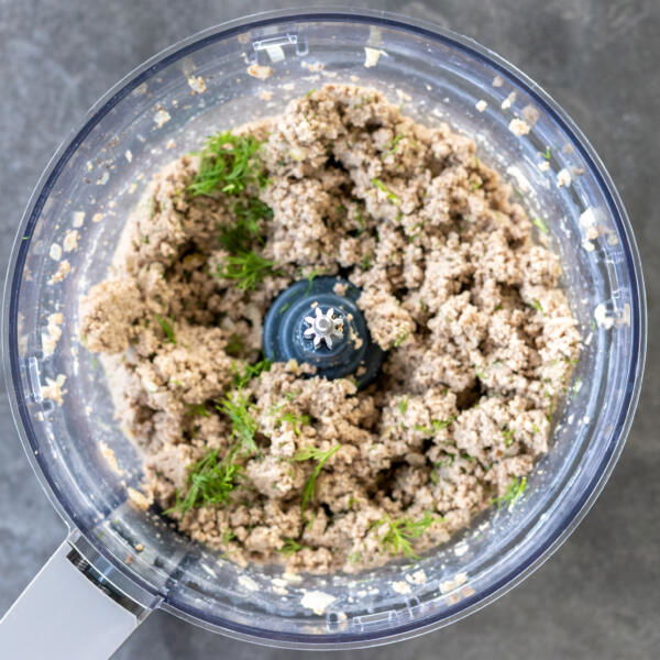 Blended meat with herbs in a food processor.