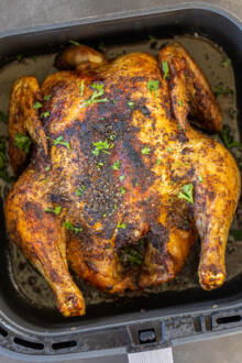 Chicken in an Air Fryer basket.