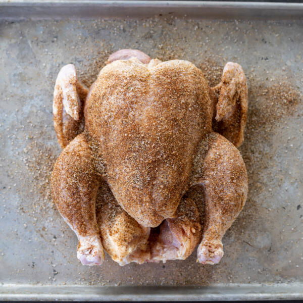 Chicken seasoned on a bakingsheet.