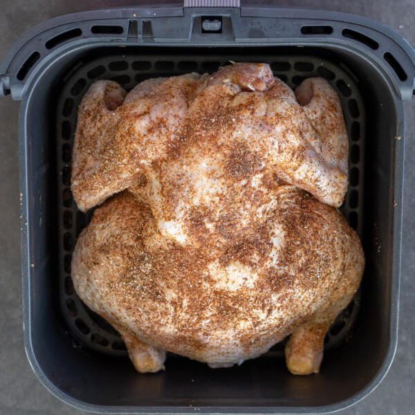 Chicken in an air fryer basket.