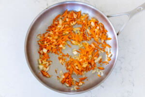 Onion and carrots in a pan.