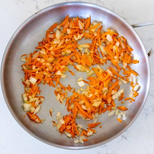 Onion and carrots in a pan.