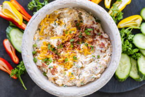 Crack Dip on a tray with veggies around.