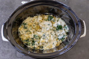 All the Spinach Artichoke Dip ingredients in a crock pot.