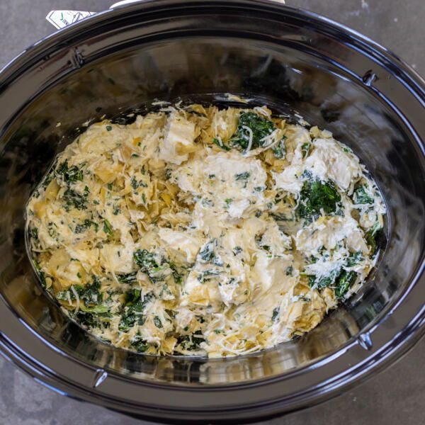 All the Spinach Artichoke Dip ingredients in a crock pot.