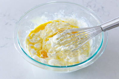 Eggs, salt and sour cream whisked in a bowl