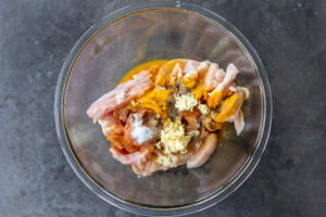 Chicken with seasoning in a bowl.