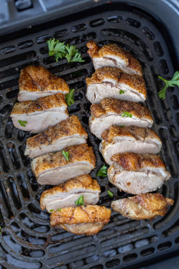 Sliced duck breast in an air fryer basket. 