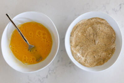 Eggs and crumbs in two bowl.
