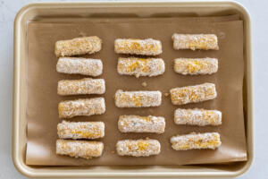Cheese sticks on a baking sheet.