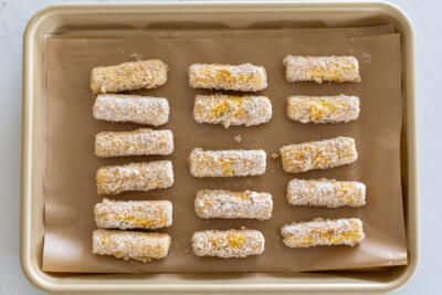 Cheese sticks on a baking sheet.