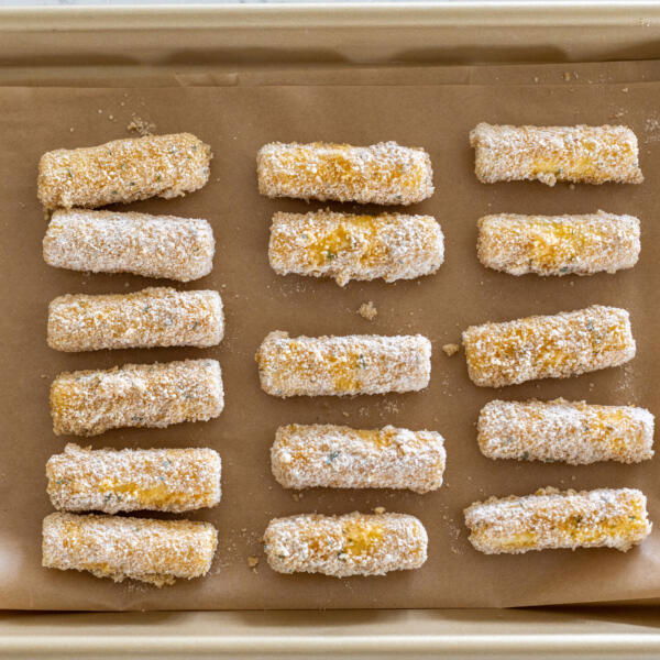 Cheese sticks on a baking sheet.