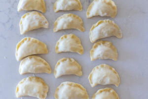 pinched closed varenyky on a floured surface.