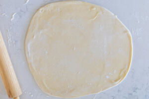 Rolled out dough on a floured surface.