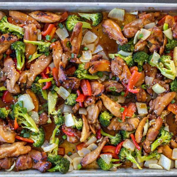 Veggies added to the chicken on a sheetpan.