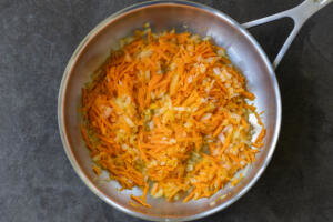 Onion and carrots in a pan.