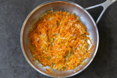 Onion and carrots in a pan.