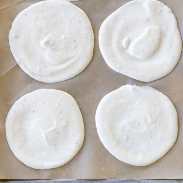 Lined baking sheet with parchment paper and cottage cheese flatbread batter.