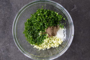parsley, galic, oil, lemon, salt and pepper in a bowl.