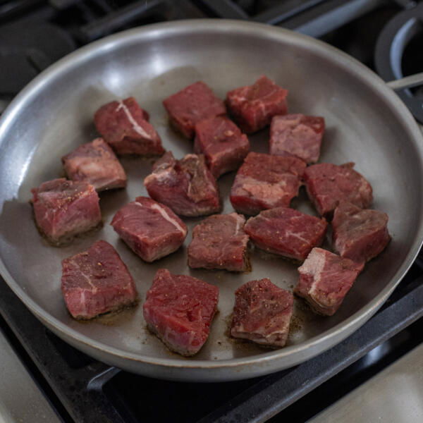 Seasoned steak in a pan.