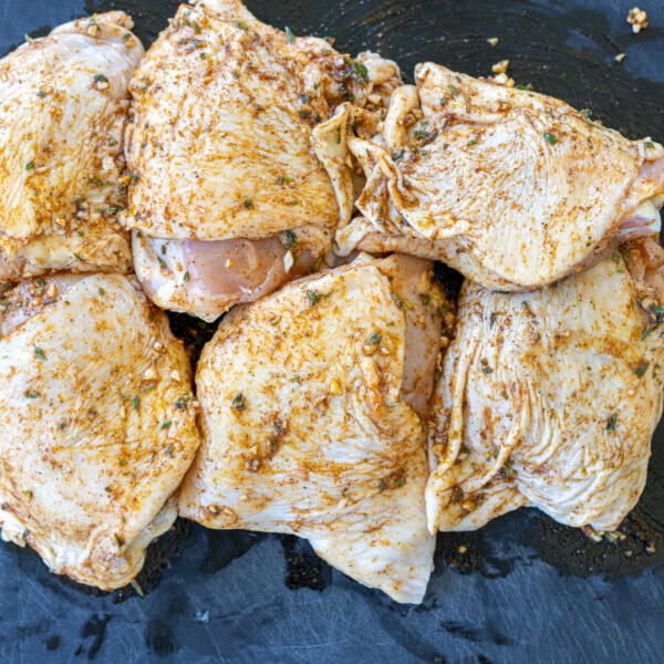 Seasoned chicken on a tray.