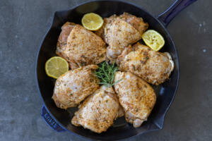 Baking pan with chicken seasoning and herbs.