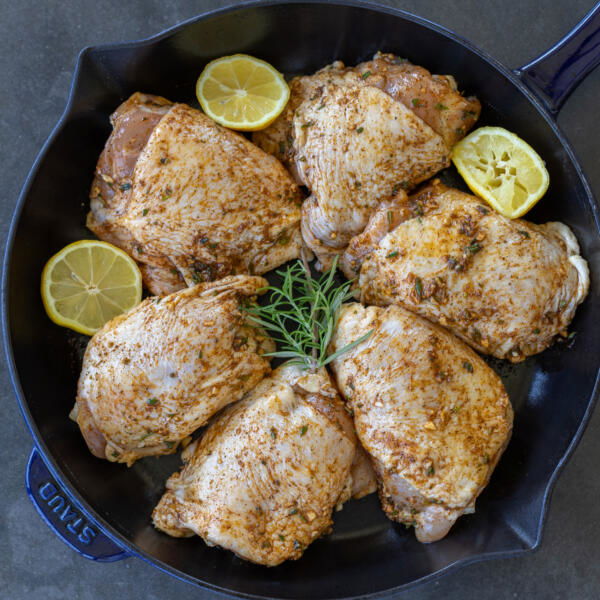 Baking pan with chicken seasoning and herbs.