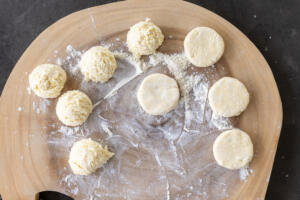 Syrniki on a floured surface.