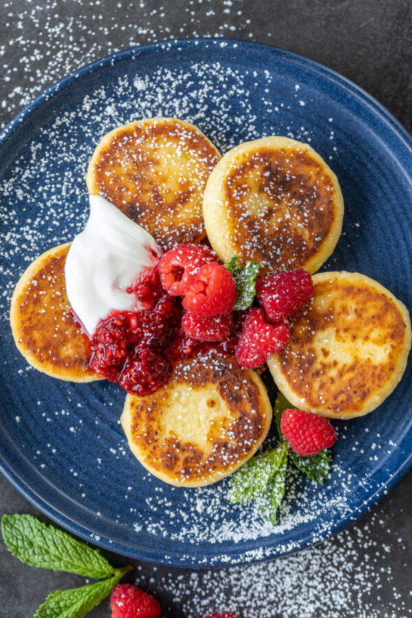 Syrniki with berries and sauce.