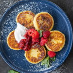 Syrniki with berries and sourcream.