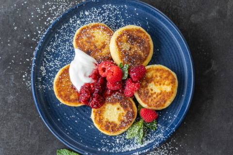 Syrniki with berries and sourcream.