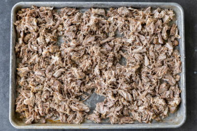 Shaved pork on a baking sheet.