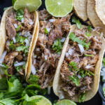 Pork Tacos with toppings and herbs.