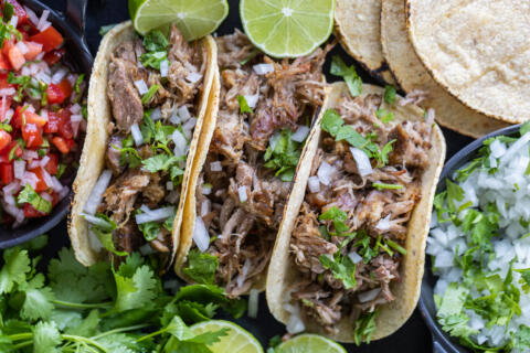 Pork Tacos with toppings and herbs.
