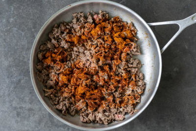 Cooked beef with taco seasoning in a pan.
