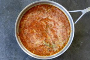 Tomato puree, chicken broth and dill in a pan.