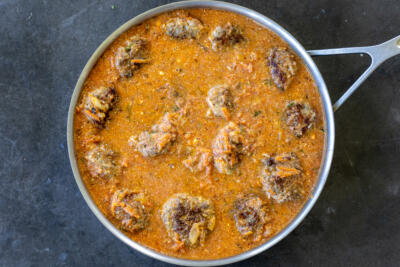Tefteli in a creamy sauce in a pan.