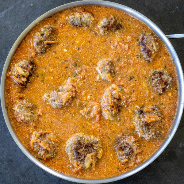 Tefteli in a creamy sauce in a pan.