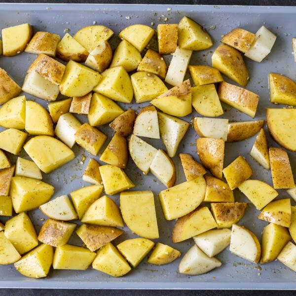 Sliced up potatoes on a baking sheet.