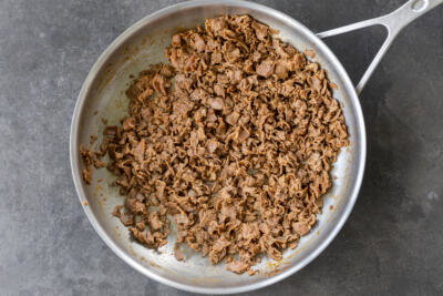 Cooked shaved beef in a pan.