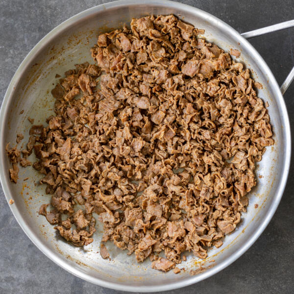 Cooked shaved beef in a pan.